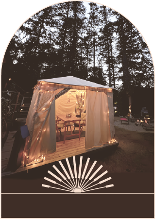 Lit canvas tent in a forest clearing at dusk